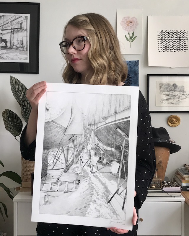 Artist Jenna Laine holding an ink drawing.
